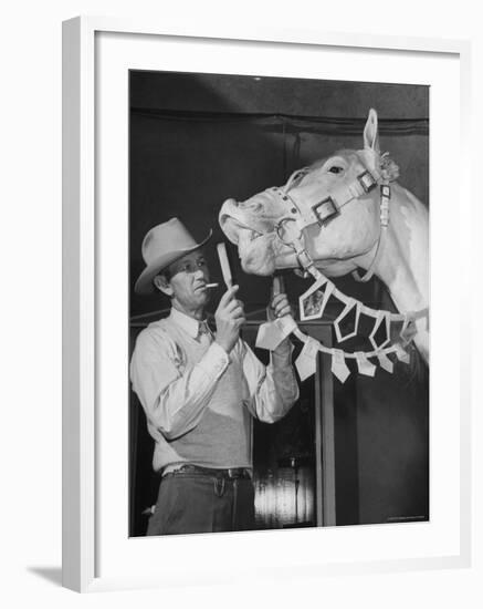 Groom Cleaning Horse's Teeth During Filming of the Movie "The Ziegfeld Follies"-John Florea-Framed Photographic Print