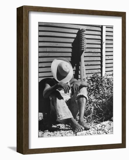 Haitian Native Engaged in a Siesta Next to Giant American Toothbrush Ad He Totes Around the Streets-Rex Hardy Jr.-Framed Photographic Print