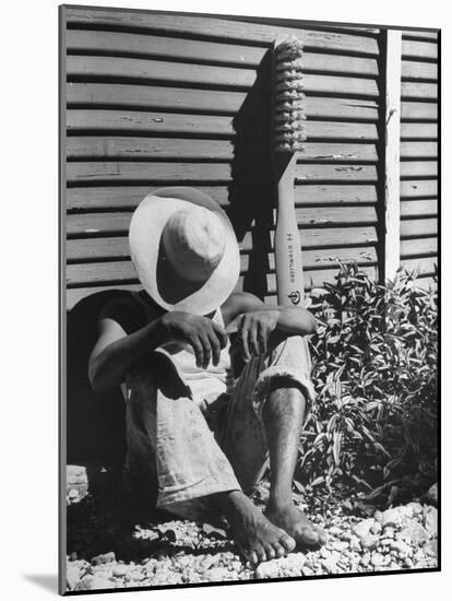 Haitian Native Engaged in a Siesta Next to Giant American Toothbrush Ad He Totes Around the Streets-Rex Hardy Jr.-Mounted Photographic Print