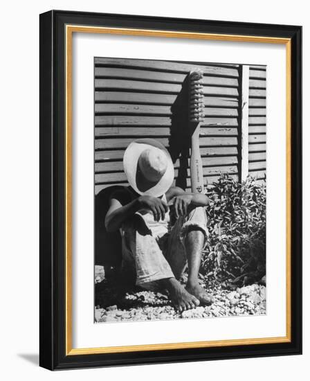 Haitian Native Engaged in a Siesta Next to Giant American Toothbrush Ad He Totes Around the Streets-Rex Hardy Jr.-Framed Photographic Print