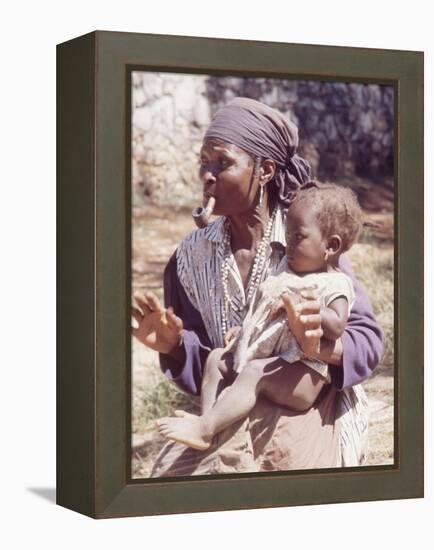 Haitian Woman Smoking a Pipe while Holding a Baby-Lynn Pelham-Framed Premier Image Canvas