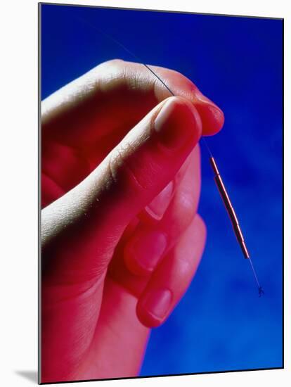 Hand Holds a GyneFIX Intrauterine Contraceptive-Damien Lovegrove-Mounted Photographic Print