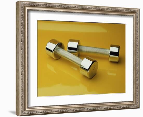 Hand Weights on a Reflective Yellow Surface-null-Framed Photographic Print