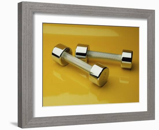 Hand Weights on a Reflective Yellow Surface-null-Framed Photographic Print