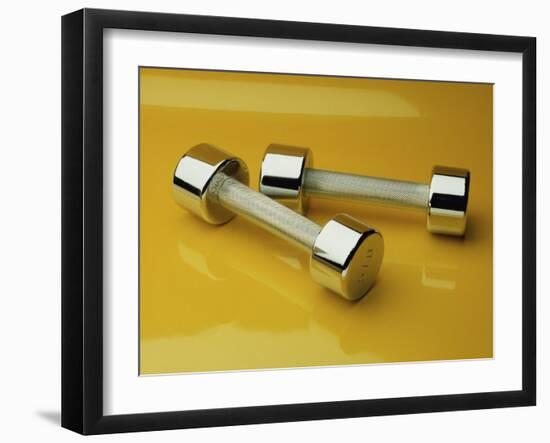 Hand Weights on a Reflective Yellow Surface-null-Framed Photographic Print