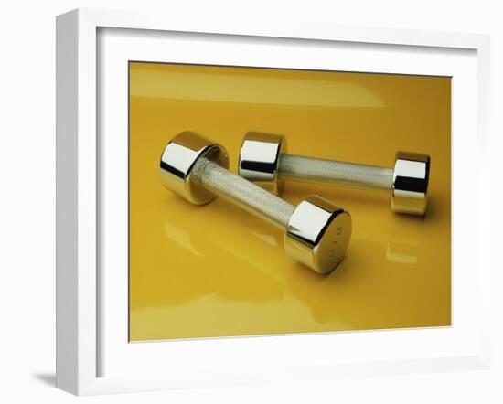 Hand Weights on a Reflective Yellow Surface-null-Framed Photographic Print