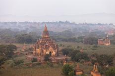 Golden Buddha Statue in Front of Burmese Writing on Wall, Bagan, Myanmar-Harry Marx-Photographic Print