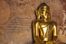 Golden Buddha Statue in Front of Burmese Writing on Wall, Bagan, Myanmar-Harry Marx-Photographic Print