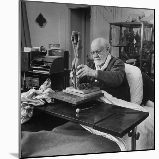 Henri Matisse Sculpting Nude Female Figure While Sitting in Bed in His Apartment-Dmitri Kessel-Mounted Premium Photographic Print