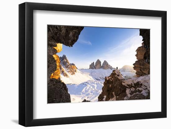 Hiker on rocks admiring Tre Cime di Lavaredo and Monte Paterno covered with snow-Roberto Moiola-Framed Photographic Print