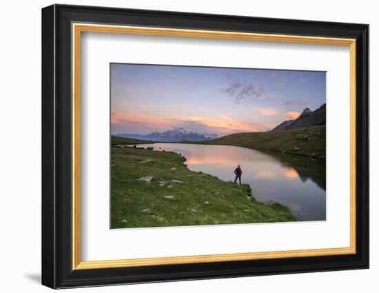 Hiker on the Shore Admires the Pink Colors of Dawn Reflected in Lake Campagneda, Valtellina, Italy-Roberto Moiola-Framed Photographic Print