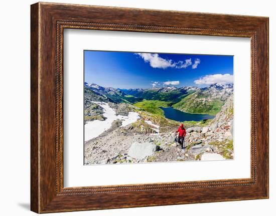 Hiker walking on mountain ridge above the blue lake Montespluga, Madesimo, Valle Spluga, Valtellina-Roberto Moiola-Framed Photographic Print