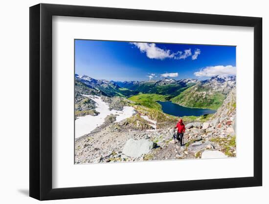 Hiker walking on mountain ridge above the blue lake Montespluga, Madesimo, Valle Spluga, Valtellina-Roberto Moiola-Framed Photographic Print