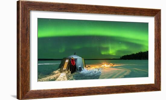 Hiker watching the Aurora Borealis (Northern Lights) close to bonfire and igloo-Roberto Moiola-Framed Photographic Print