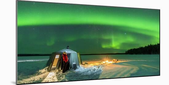 Hiker watching the Aurora Borealis (Northern Lights) close to bonfire and igloo-Roberto Moiola-Mounted Photographic Print