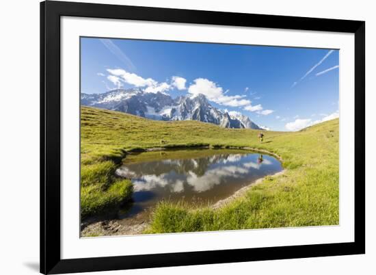 Hiker with dog admires the peaks of Mont De La Saxe reflected in water, Courmayeur, Aosta Valley, I-Roberto Moiola-Framed Photographic Print