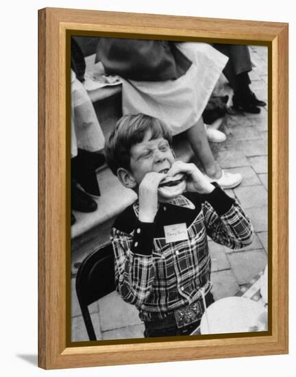 Hollywood Child Timmy Garry at Children's party Dressed in Cowboy Outfit eating a Hamburger-J^ R^ Eyerman-Framed Premier Image Canvas