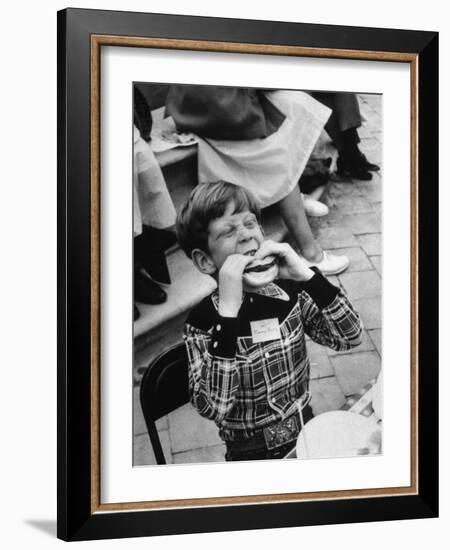 Hollywood Child Timmy Garry at Children's party Dressed in Cowboy Outfit eating a Hamburger-J^ R^ Eyerman-Framed Photographic Print