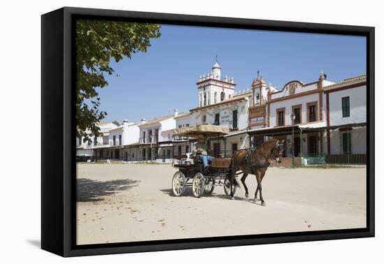 Horse and carriage riding along sand streets with brotherhood houses behind, El Rocio, Huelva Provi-Stuart Black-Framed Premier Image Canvas