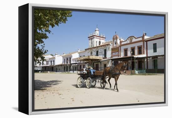 Horse and carriage riding along sand streets with brotherhood houses behind, El Rocio, Huelva Provi-Stuart Black-Framed Premier Image Canvas