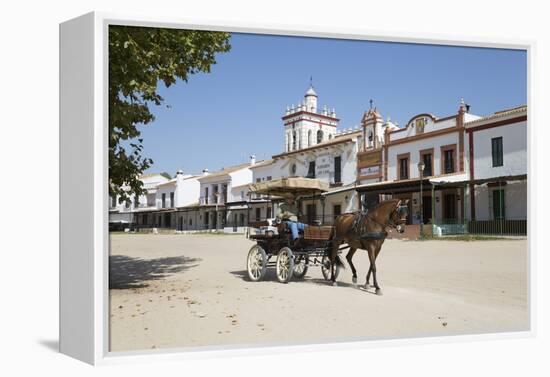 Horse and carriage riding along sand streets with brotherhood houses behind, El Rocio, Huelva Provi-Stuart Black-Framed Premier Image Canvas