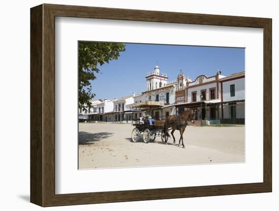 Horse and carriage riding along sand streets with brotherhood houses behind, El Rocio, Huelva Provi-Stuart Black-Framed Photographic Print