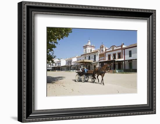 Horse and carriage riding along sand streets with brotherhood houses behind, El Rocio, Huelva Provi-Stuart Black-Framed Photographic Print