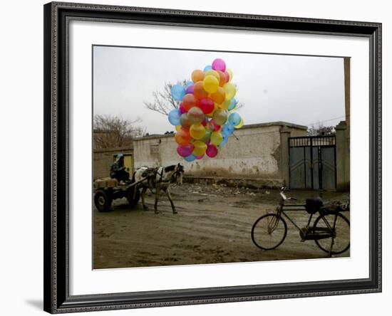 Horse Drawn Cart Drives Past as Balloons Tied to a Bicycle Flutter in the Wind-null-Framed Photographic Print