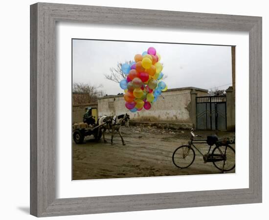 Horse Drawn Cart Drives Past as Balloons Tied to a Bicycle Flutter in the Wind-null-Framed Photographic Print