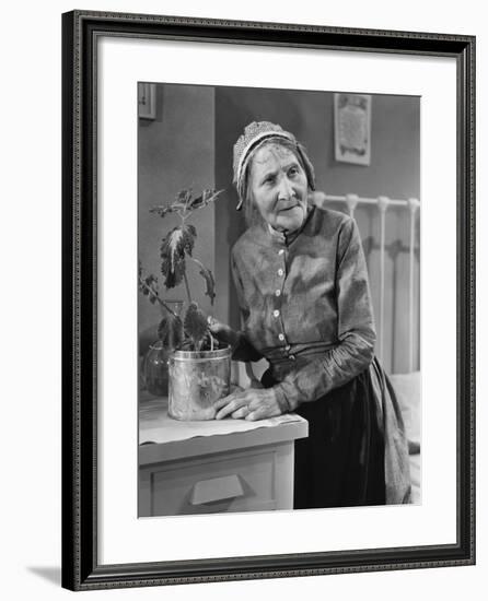 Housekeeper Tending to Plant-null-Framed Photo