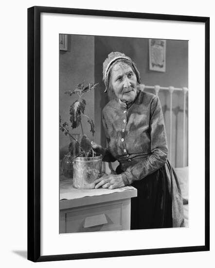 Housekeeper Tending to Plant-null-Framed Photo