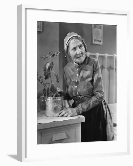 Housekeeper Tending to Plant-null-Framed Photo