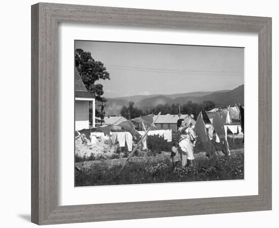 Housewife in Tygart Valley Removing Laundry from Clothesline, Her Young Daughter Stands Beside Her-Carl Mydans-Framed Photographic Print