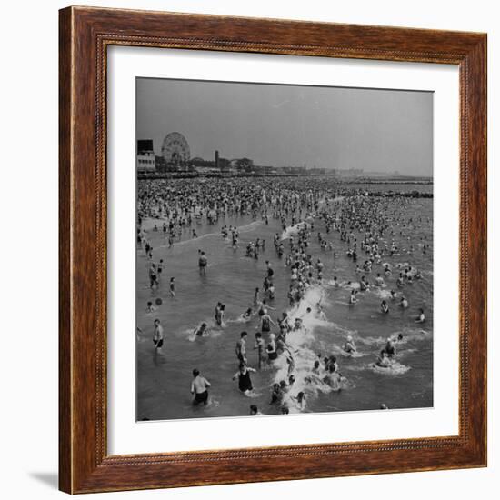 Huge Crowd Gathered in the Surf and at the Beach in Front of Coney Island Amusement Park-Marie Hansen-Framed Photographic Print