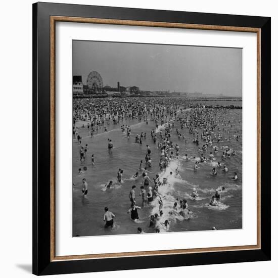 Huge Crowd Gathered in the Surf and at the Beach in Front of Coney Island Amusement Park-Marie Hansen-Framed Photographic Print