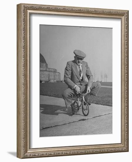 Humorous of Man Riding Tiny Bicycle-Wallace Kirkland-Framed Photographic Print