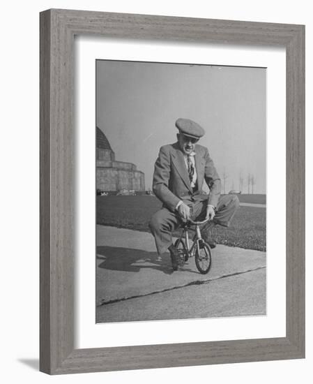 Humorous of Man Riding Tiny Bicycle-Wallace Kirkland-Framed Photographic Print