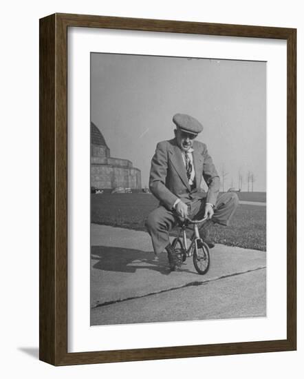 Humorous of Man Riding Tiny Bicycle-Wallace Kirkland-Framed Photographic Print
