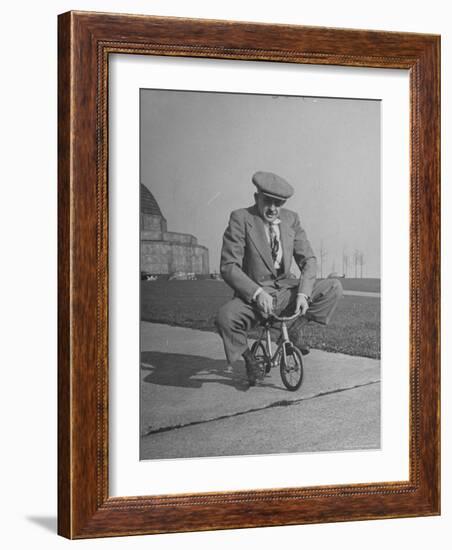 Humorous of Man Riding Tiny Bicycle-Wallace Kirkland-Framed Photographic Print