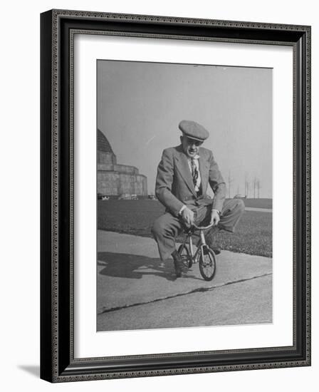 Humorous of Man Riding Tiny Bicycle-Wallace Kirkland-Framed Photographic Print