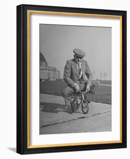 Humorous of Man Riding Tiny Bicycle-Wallace Kirkland-Framed Photographic Print