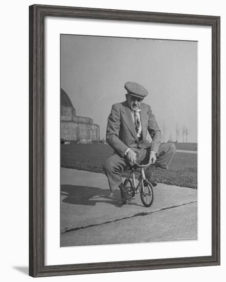 Humorous of Man Riding Tiny Bicycle-Wallace Kirkland-Framed Photographic Print