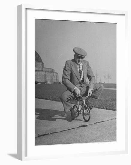 Humorous of Man Riding Tiny Bicycle-Wallace Kirkland-Framed Photographic Print