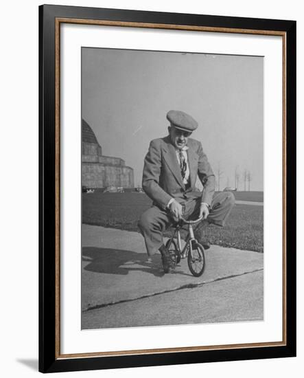 Humorous of Man Riding Tiny Bicycle-Wallace Kirkland-Framed Photographic Print