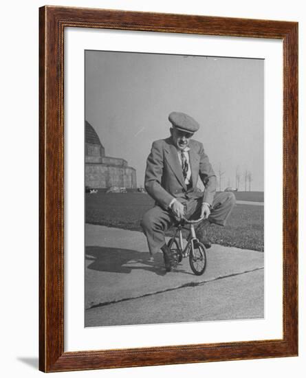 Humorous of Man Riding Tiny Bicycle-Wallace Kirkland-Framed Photographic Print