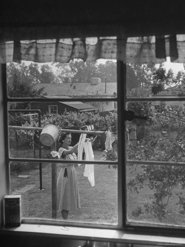 Photographic Print: Suburban Housewife Hanging Out a Bit of Laundry, Seen Through Window in typical California Home by Loomis Dean: 16x12in