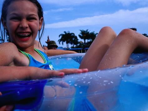 Photographic Print: Young Girl Floating in Swimming Pool in Rubber Ring, Gold Coast, Australia by Richard I'Anson: 24x18in