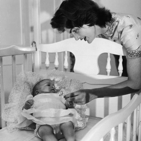 Premium Photographic Print: Sen. John Kennedy's Wife Jacqueline Offering Baby Caroline a Silver Rattle at their Georgetown Home by Nina Leen: 16x16in