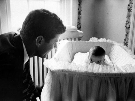 Photographic Print: Sen. John F. Kennedy Playing Peek-A-Boo with His Daughter Caroline in Her Crib by Ed Clark: 24x18in