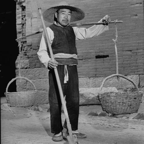 Photographic Print: Night Soil Collector on Way to Work Armed with Long Spade and Baskets: 16x16in